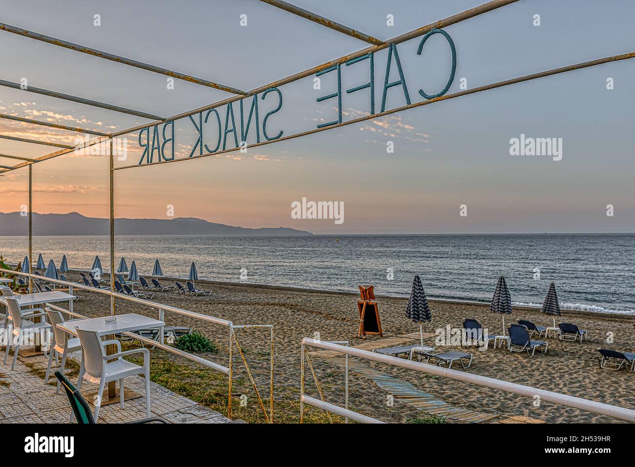 a snack bar with no tourists overlooking the beach and the azure Mediterranean Sea, Crete, Greece, October 11, 2021 Stock Photo