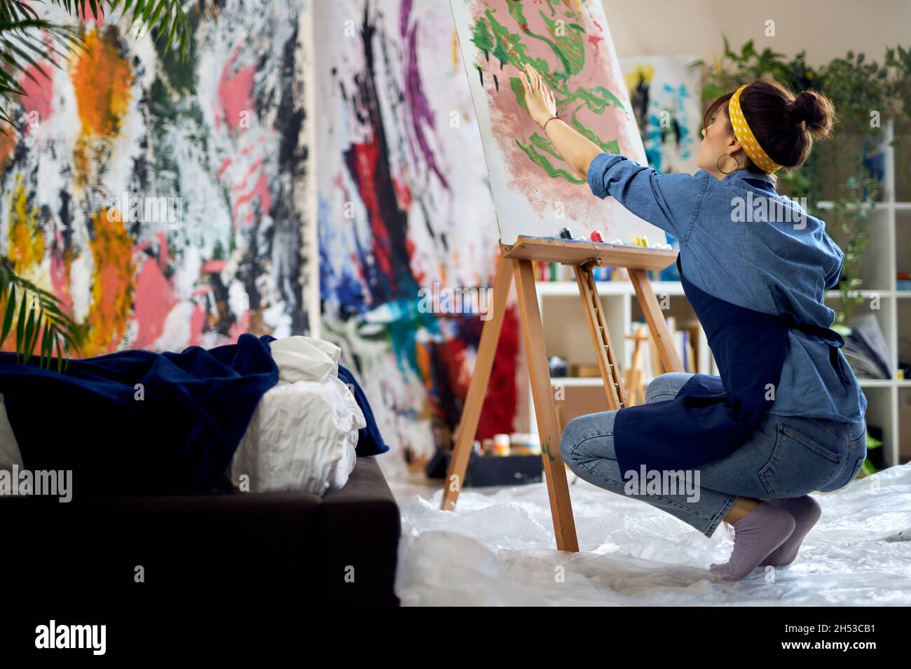 Inspired woman, female artist in apron creating abstract painting at ...