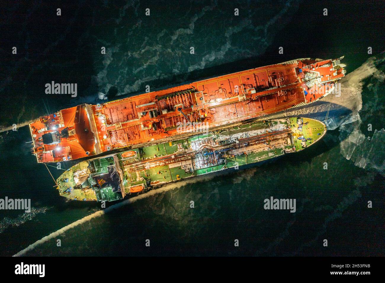 https://c8.alamy.com/comp/2H53FNB/two-tankers-at-night-stand-nearby-in-young-ice-shooting-from-air-2H53FNB.jpg