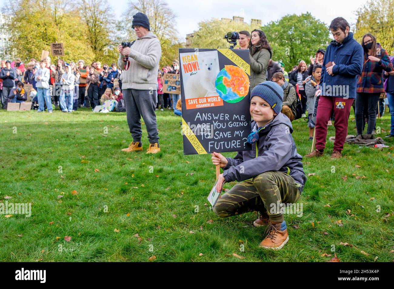 Bristol, UK, 6th November, 2021. A young boy holds up a placard as protesters listen to speeches before they take part in a climate change protest march through the centre of Bristol. The protest was one of hundreds held around the world today as people took to the streets to push world leaders to act as their negotiators meet in Glasgow at the COP 2021 United Nations Climate Change Conference. Credit: Lynchpics/Alamy Live News Stock Photo