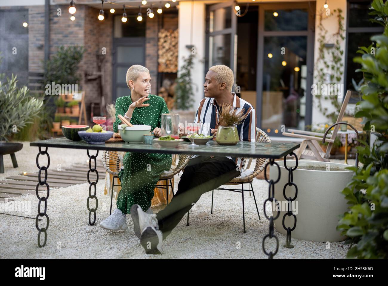 Multiracial couple having dinner at their backyard Stock Photo