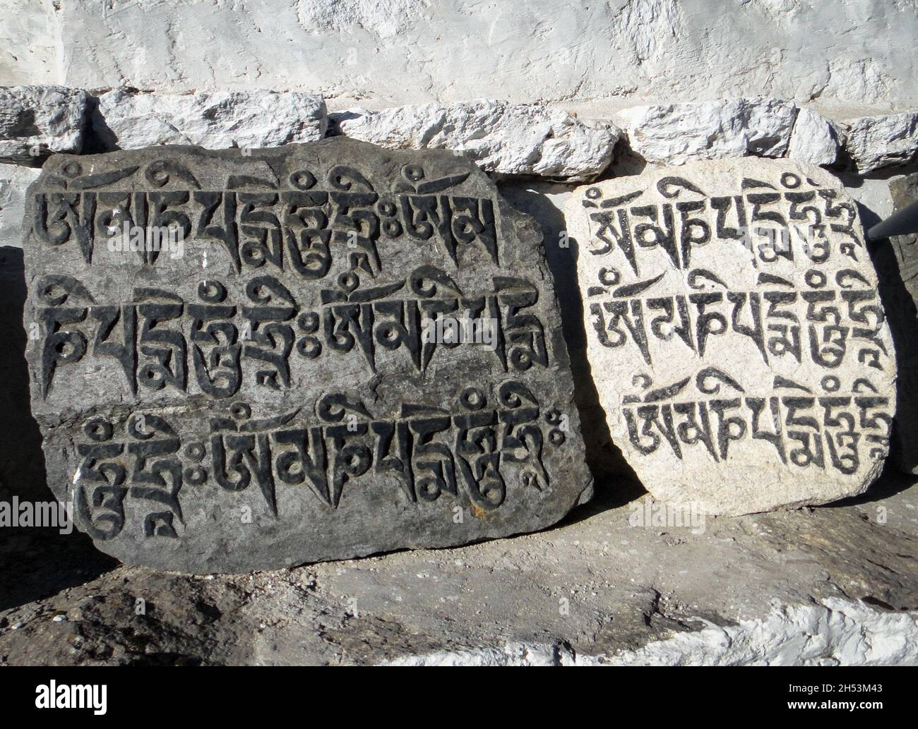 Buddhist mantras (Om Manne Padme Hum) engraved in stones. The writing in the stones are Buddhist Mantras "Om Manne Padme Hum". Stock Photo