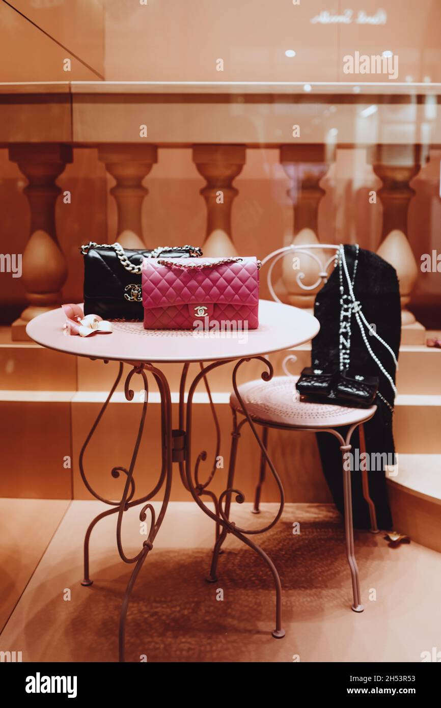 Pink and black Chanel handbags in the window of a luxury store