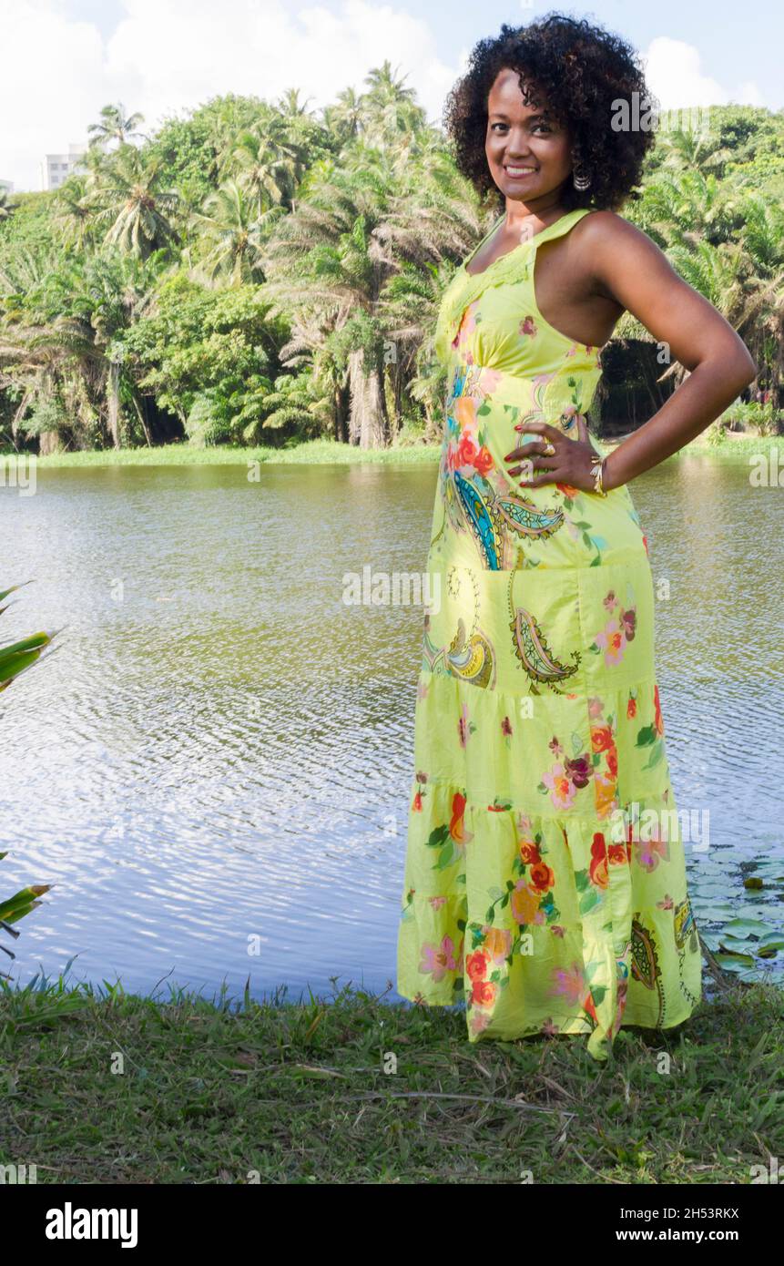 Woman with predominant green colored dress posing for photo among trees ...