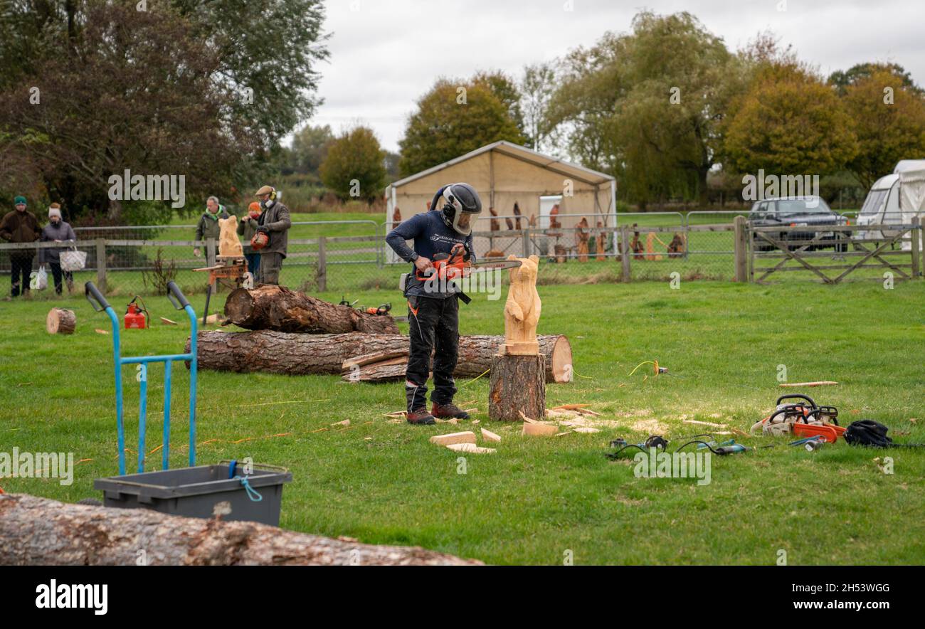Wood Carvers in action with chainsaws at the Berkshire Craft, Food & Gift Fair, Newbury Showground, Berkshire, UK Stock Photo