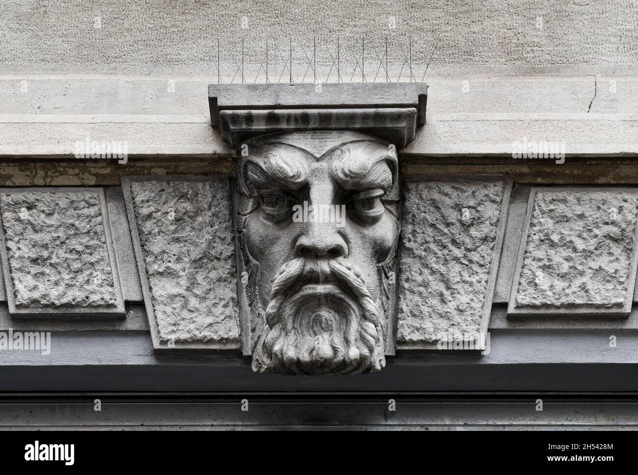 Detail of the stone bas-relief on the façade of an old building representing the face of a bearded man, Parma, Emilia-Romagna, Italy Stock Photo