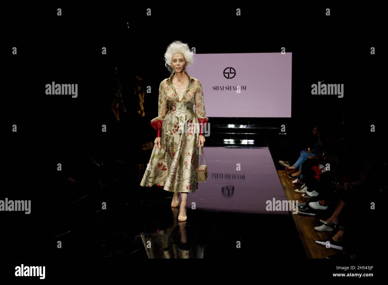 Kornit Fashion Show 2021 Los Angeles - Designer Shai Shalom. Models walk catwalk to a pink screen with designer logo. Gust Actress Linda Gray walks Stock Photo