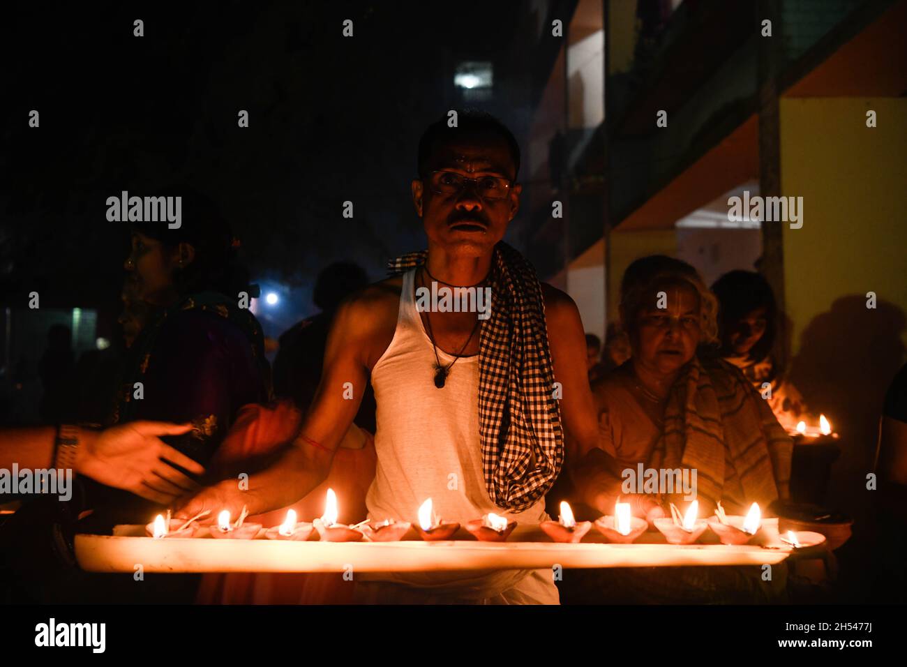 Narayanganj, Bangladesh. 06th Nov, 2021. A man holding burning candles offers prayers at the Shri Shri Lokanath Brahmachari Ashram temple during the Hindu religious fasting festival.Disciples of Baba Lokenath Brahmachari celebrated Rakher Upobash or kartik broto by fasting until the evening and lighting lamps at Barodi Lokenath Ashram in Narayanganj. (Photo by Piyas Biswas/SOPA Images/Sipa USA) Credit: Sipa USA/Alamy Live News Stock Photo