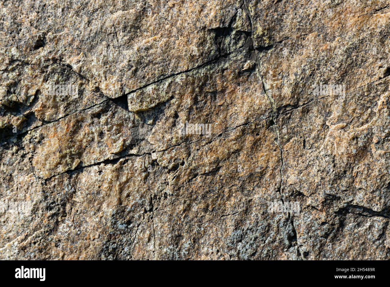 Texture of granite rock. Cracked stone surface from weathering. Close