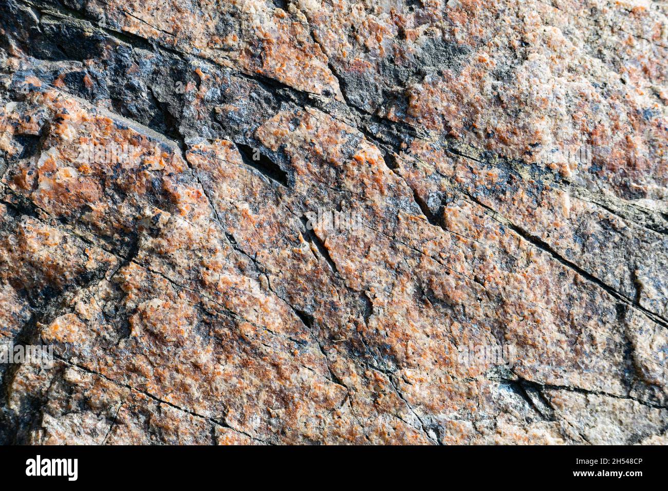 Texture of granite rock. Cracked stone surface from weathering. Close