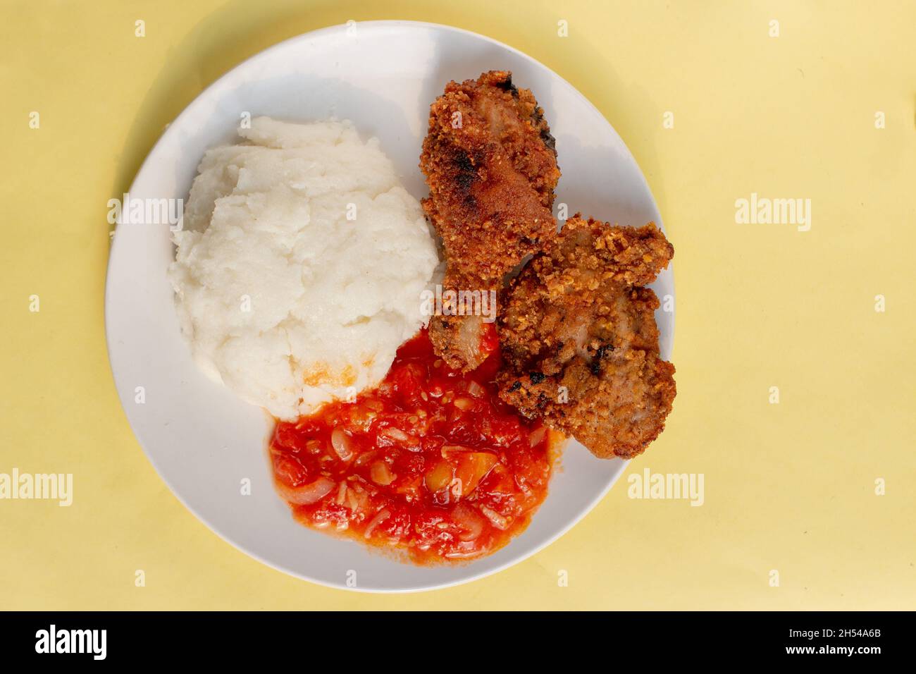 Traditional African corn meal pap staple food, fried chicken and tomato