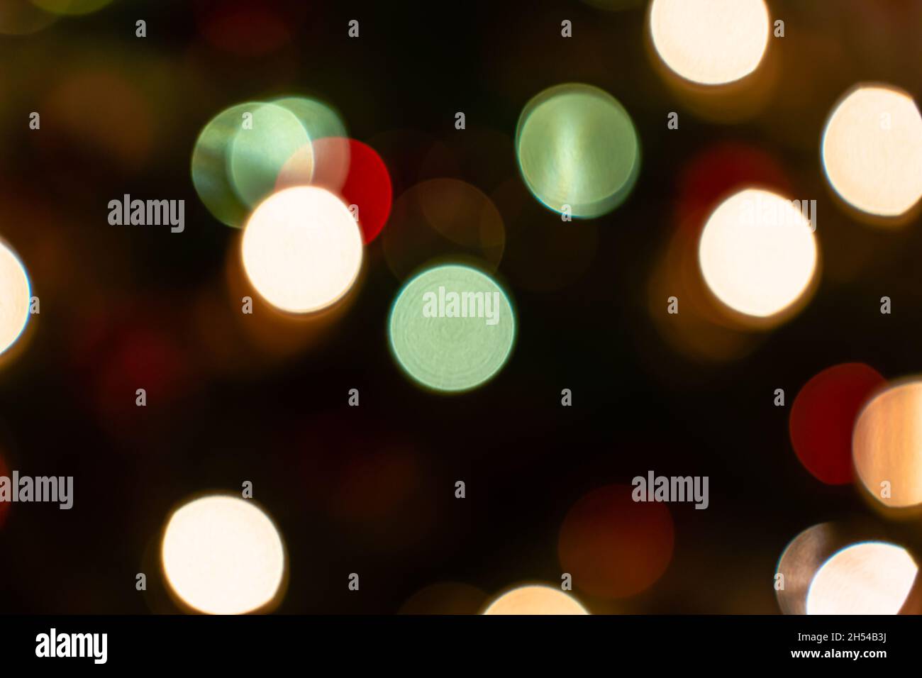 Abstract bokeh light background. Beautiful bokeh lights glowing on dark background. Festive background for Christmas holiday celebration or New-Year. Stock Photo