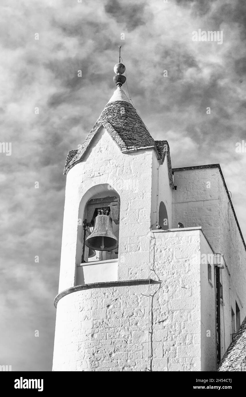 Belltower of the Trullo church in Alberobello, Italy. Trulli buildings ...