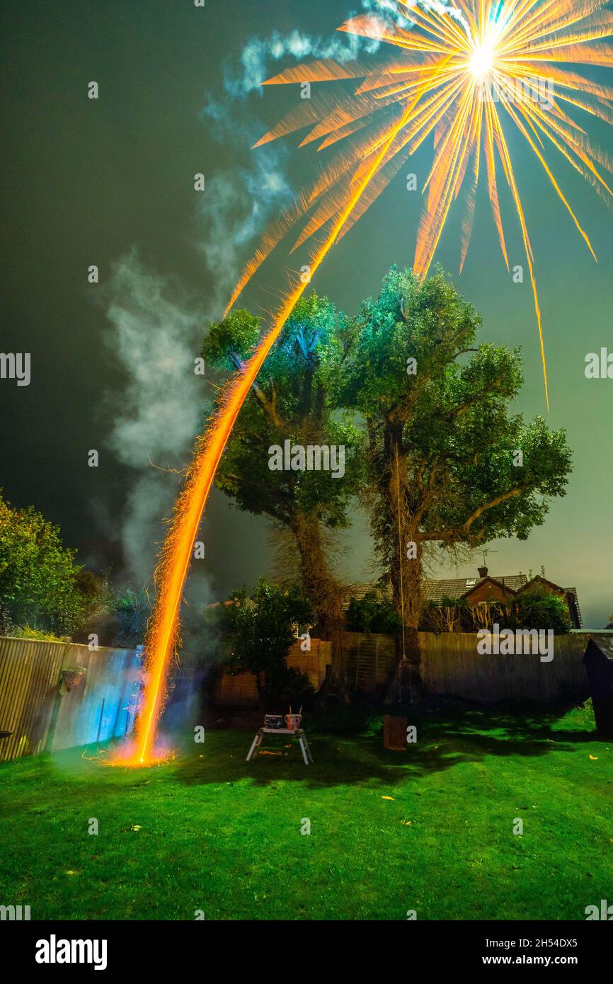 Pembury, Kent, UK. 05 November 2021. A large rocket is let off in a small garden by a large tree in a home firework show. A fire risk and dangerous in a small garden.©Sarah Mott / Alamy Live News Stock Photo