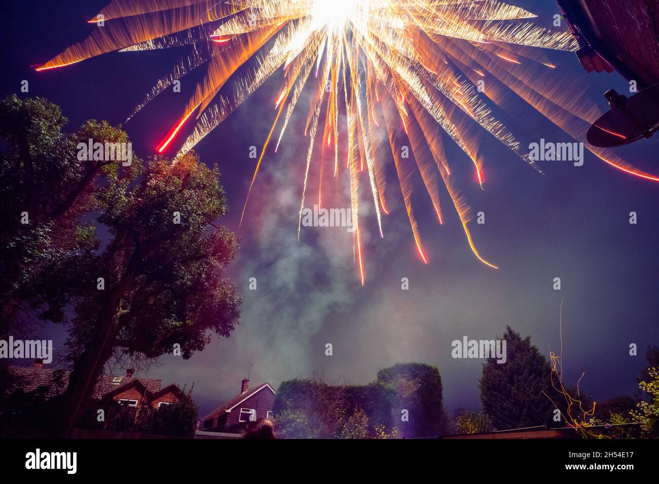 Pembury, Kent, UK. 05 November 2021. A large rocket is let off in a small garden by a large tree in a home firework show. A fire risk and dangerous in a small garden.©Sarah Mott / Alamy Live News Stock Photo