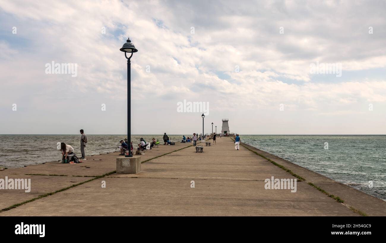 Port Maitland, Canada – July 1, 2021: People fishing at Port Maitland Esplanade and Pier with Lighthouse at the background Stock Photo