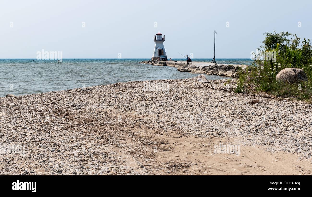Southampton, Ontario - August 5, 2021: People fishing from the pier with the lighthouse Southampton, Lake, Huron, Ontario Stock Photo