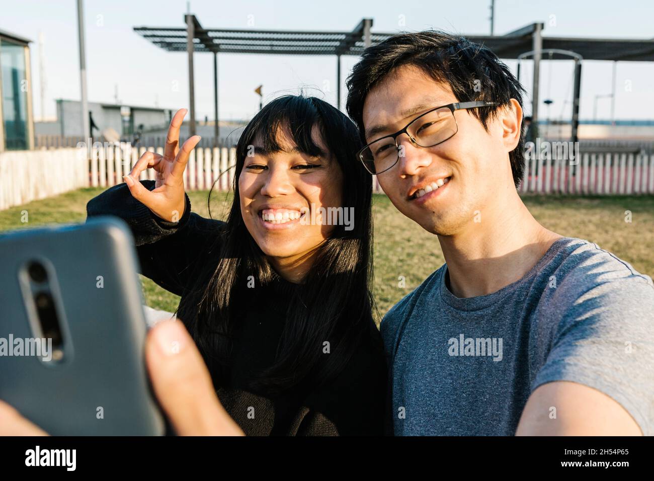 Young asian couple having fun while taking selfie with smartphone ...