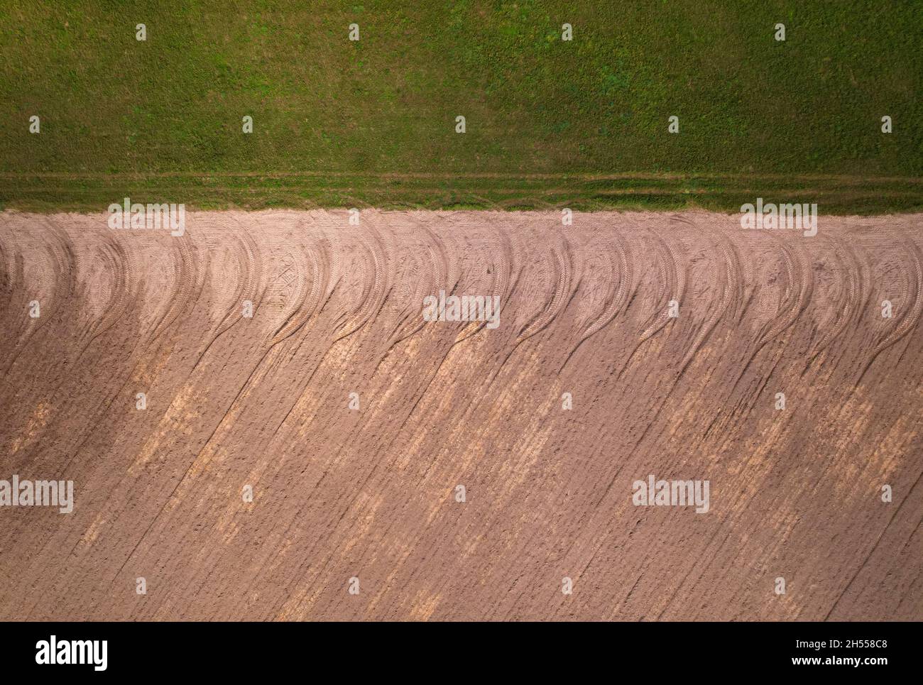 Pattern of tread marks from tractor wheels on farmland. Stock Photo