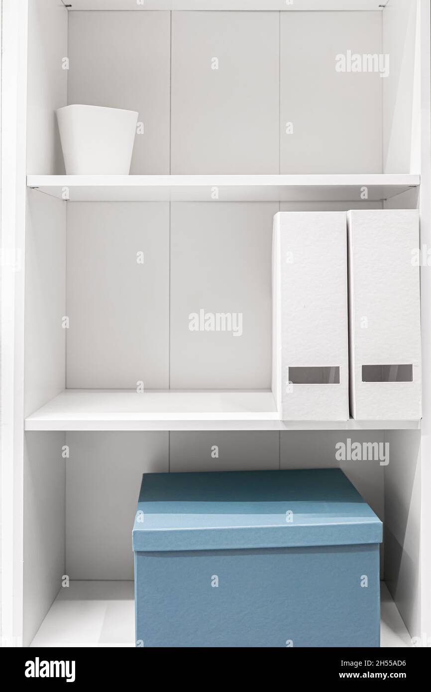 A minimalist wardrobe, halfempty shelves in a white wardrobe Stock