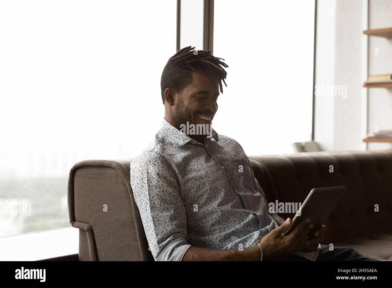 Happy young african american man using digital tablet. Stock Photo