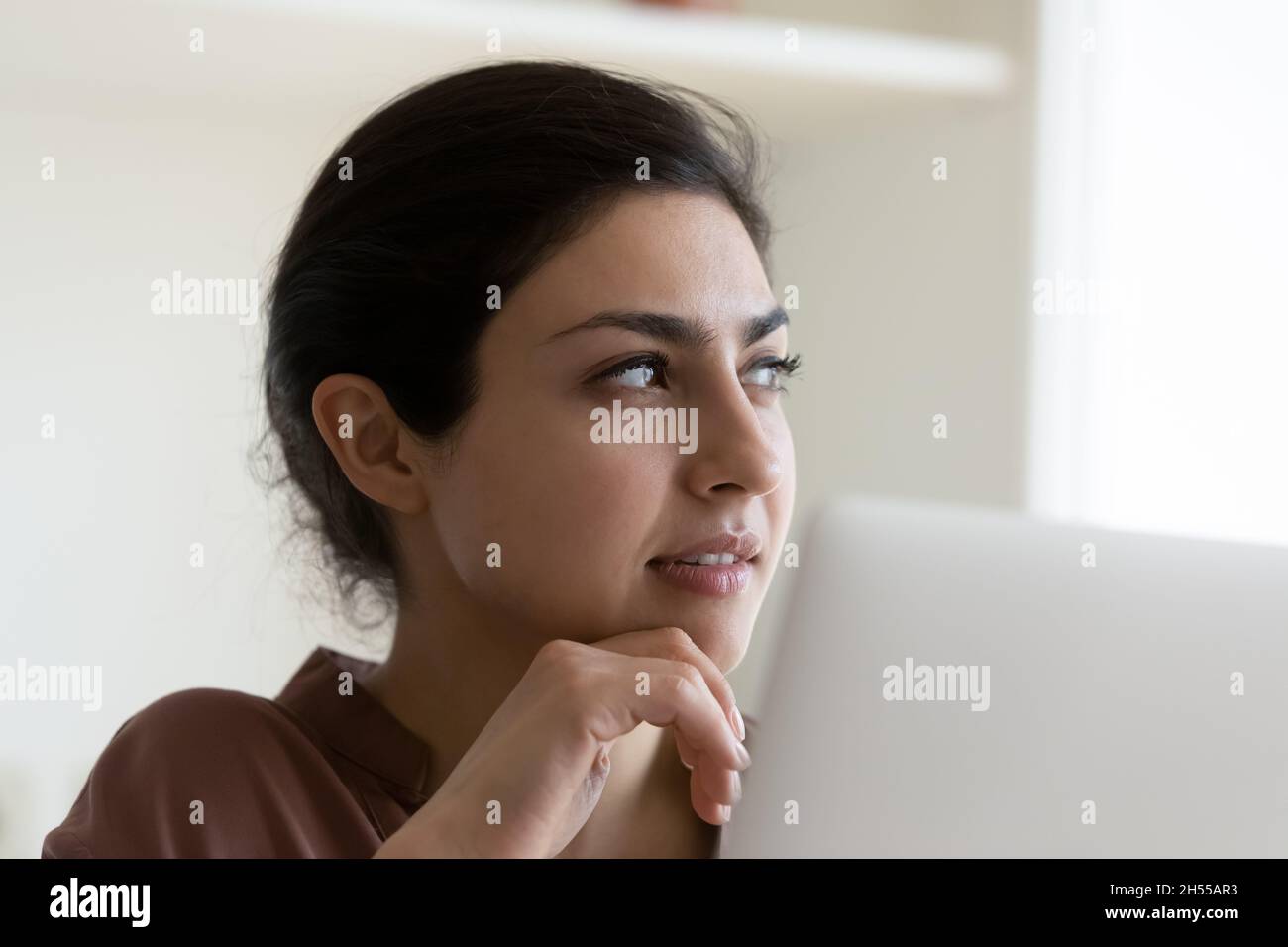 Businesswoman sit by laptop looks aside ponder on business task Stock Photo