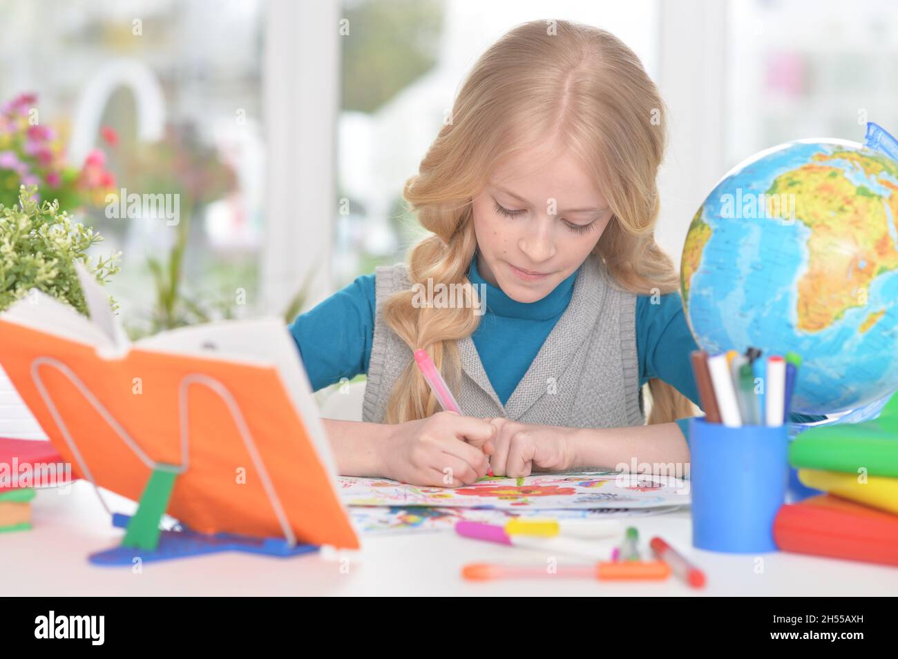 Portrait of cute little girl studying at home Stock Photo - Alamy