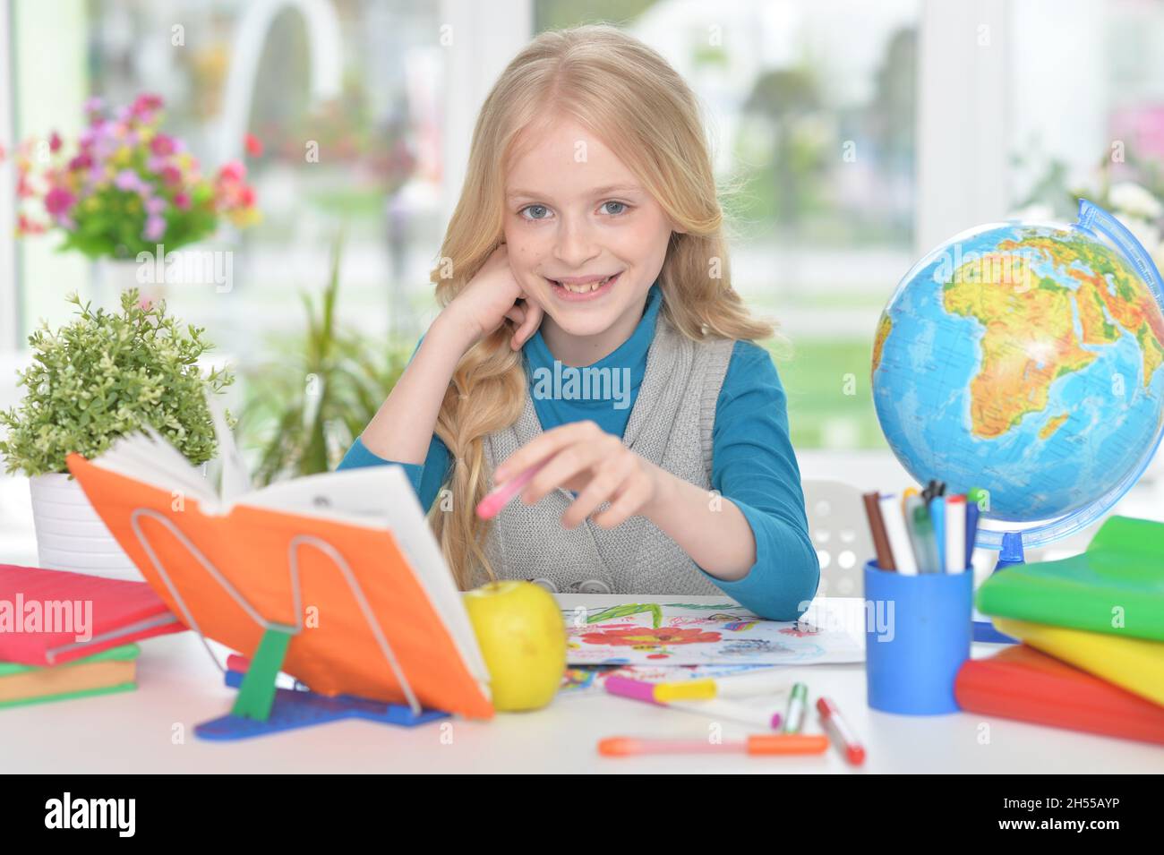 Portrait of cute little girl studying at home Stock Photo - Alamy