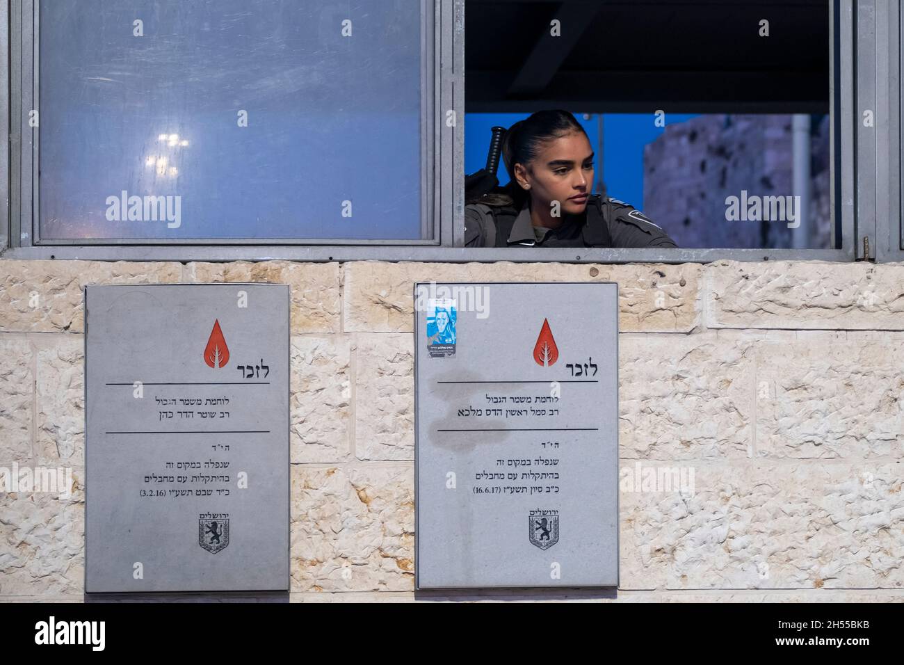 An Israeli policewoman stands guard inside a security post with memorial plaques for Border Policewomen Hadar Cohen and Hadas Malka who were murdered by Palestinians on two different occasions outside Nablus Gate or Bab al-Amud also called Damascus gate at the northern edge of the Ottoman walls surrounding the old city of Jerusalem Israel Stock Photo
