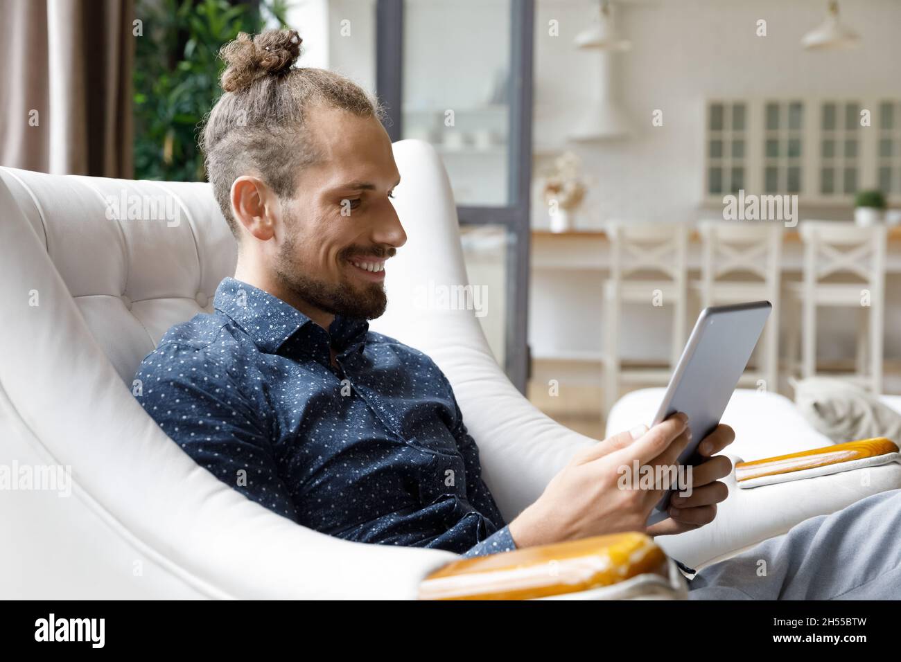 Happy young hipster man using digital touchpad gadget. Stock Photo