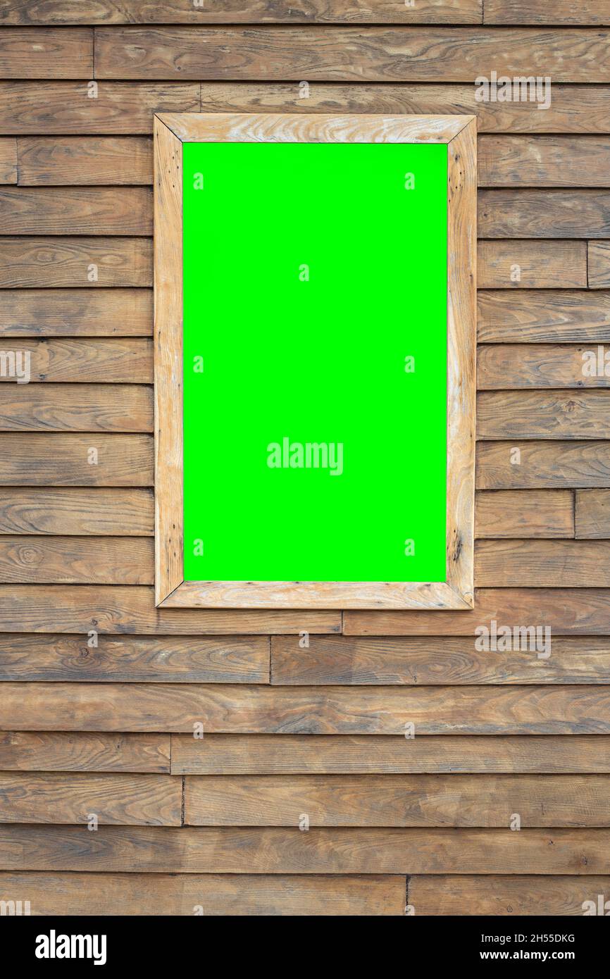 A vertical image of a wooden background with a framed window in which there is a chroma key for attaching images or video. copy space Stock Photo