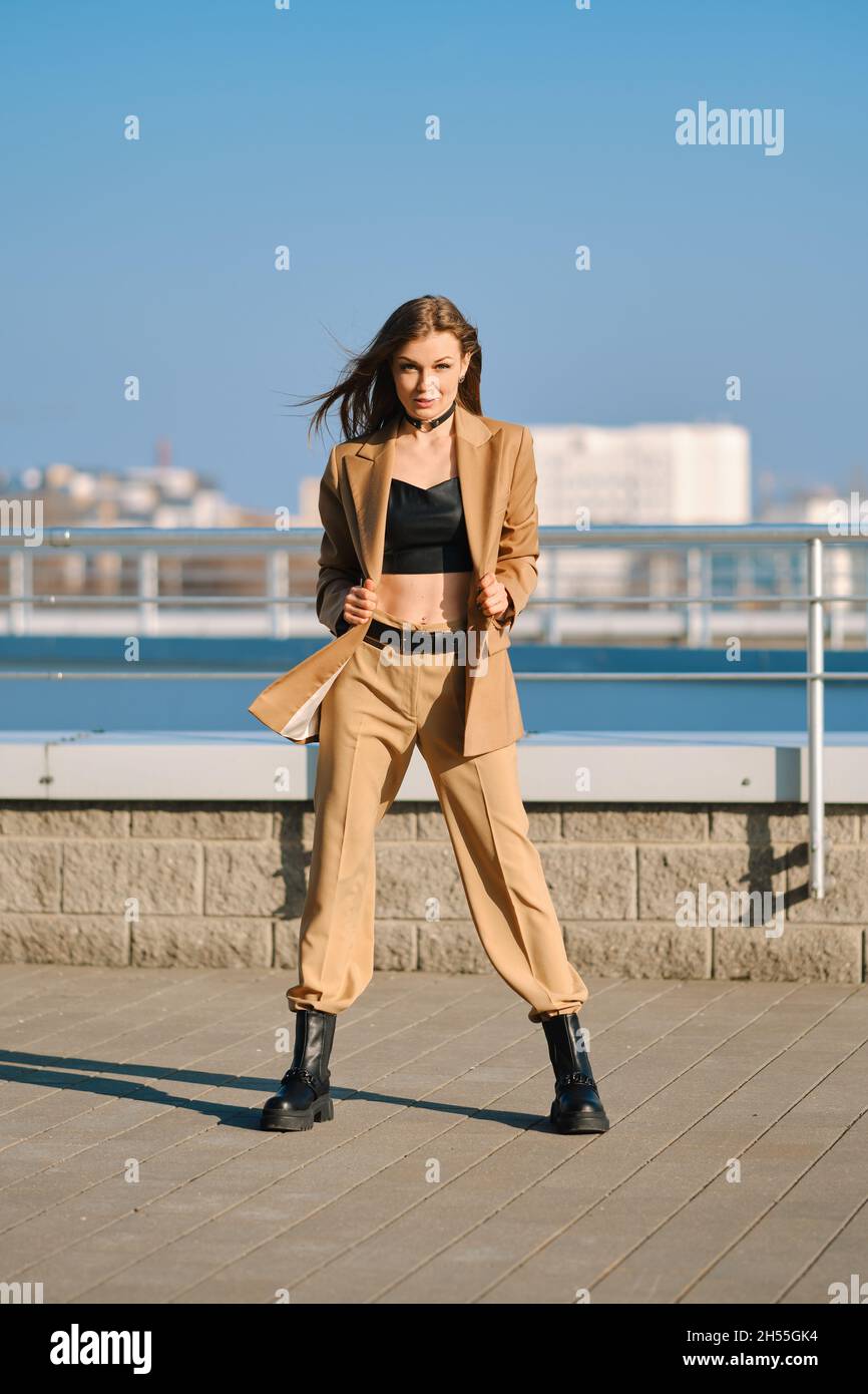 Street fashion, women casual and trendy outfit. Woman in pantsuit, leather  tank-top and rough boots outdoor Stock Photo - Alamy