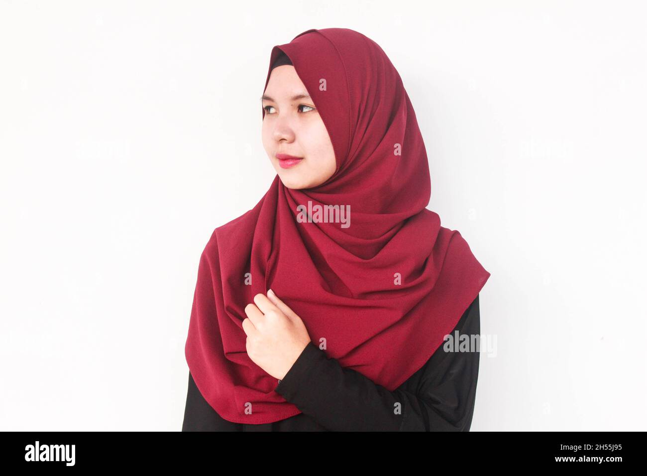 An Indonesian woman posing in a red hijab veil Stock Photo