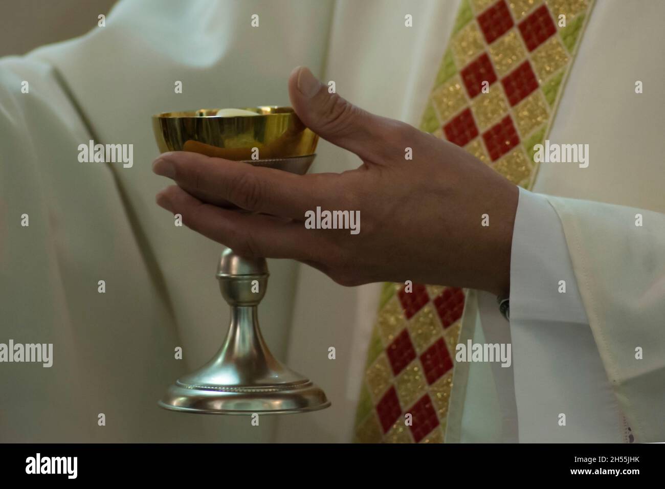 priest holding a chalice during celebration Stock Photo