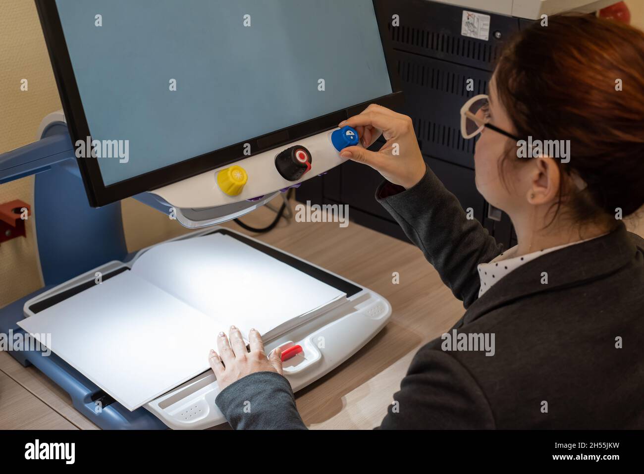 A visually impaired woman uses special reading equipment Stock Photo