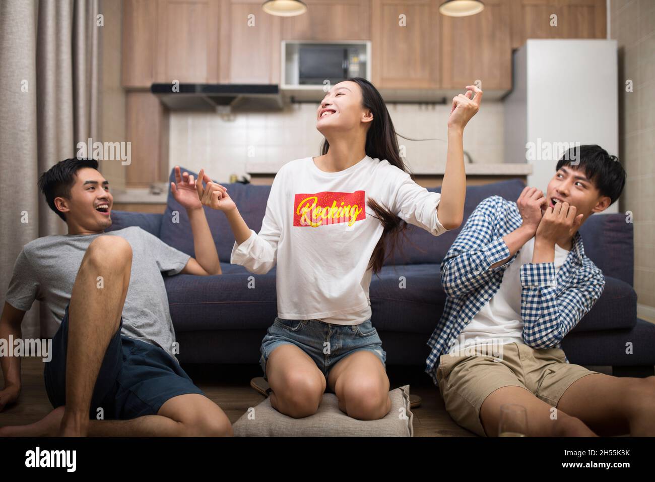 Happy young people are singing and dancing in the living room Stock ...