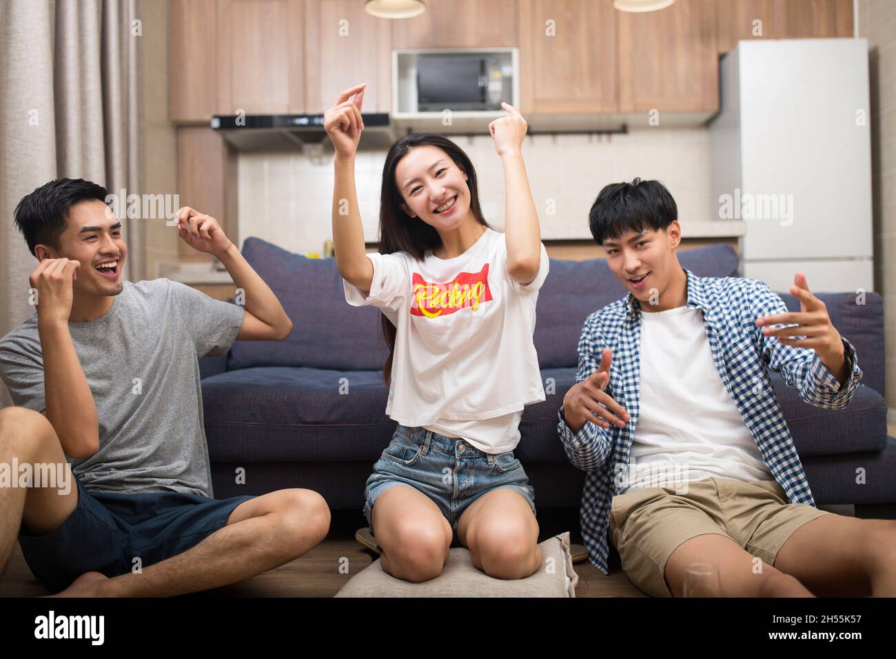 Happy young people are singing and dancing in the living room Stock ...