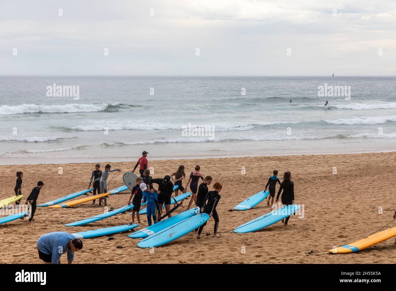Learn to surf class, group of young children on Manly Beach ready for a