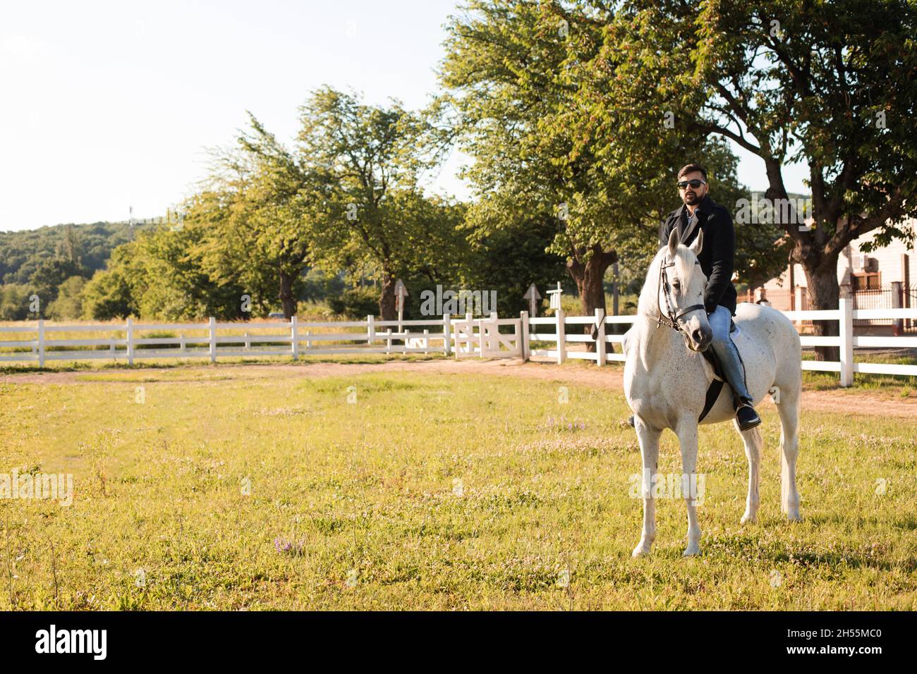 The young man is riding a horse on a farm Stock Photo - Alamy