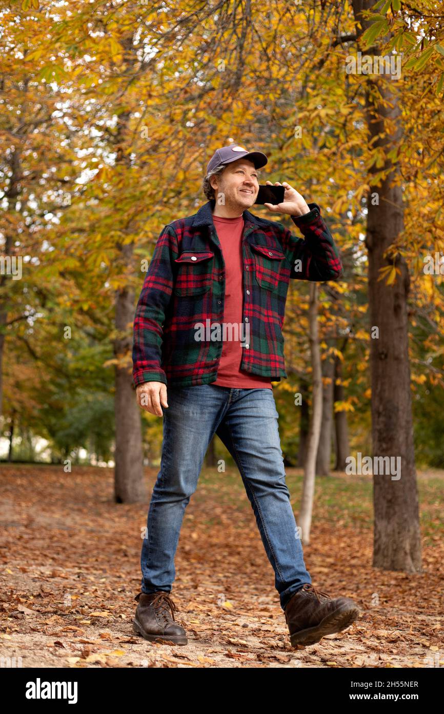 full-body man in the woods talking on the phone Stock Photo