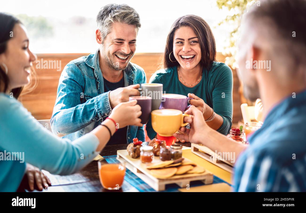 People group toasting latte at coffee bar rooftop - Friends talking and having fun together at cappuccino restaurant - Life style concept Stock Photo