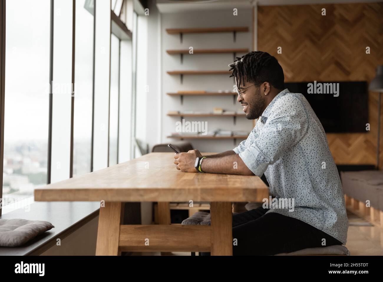 Happy millennial african american man using smartphone. Stock Photo