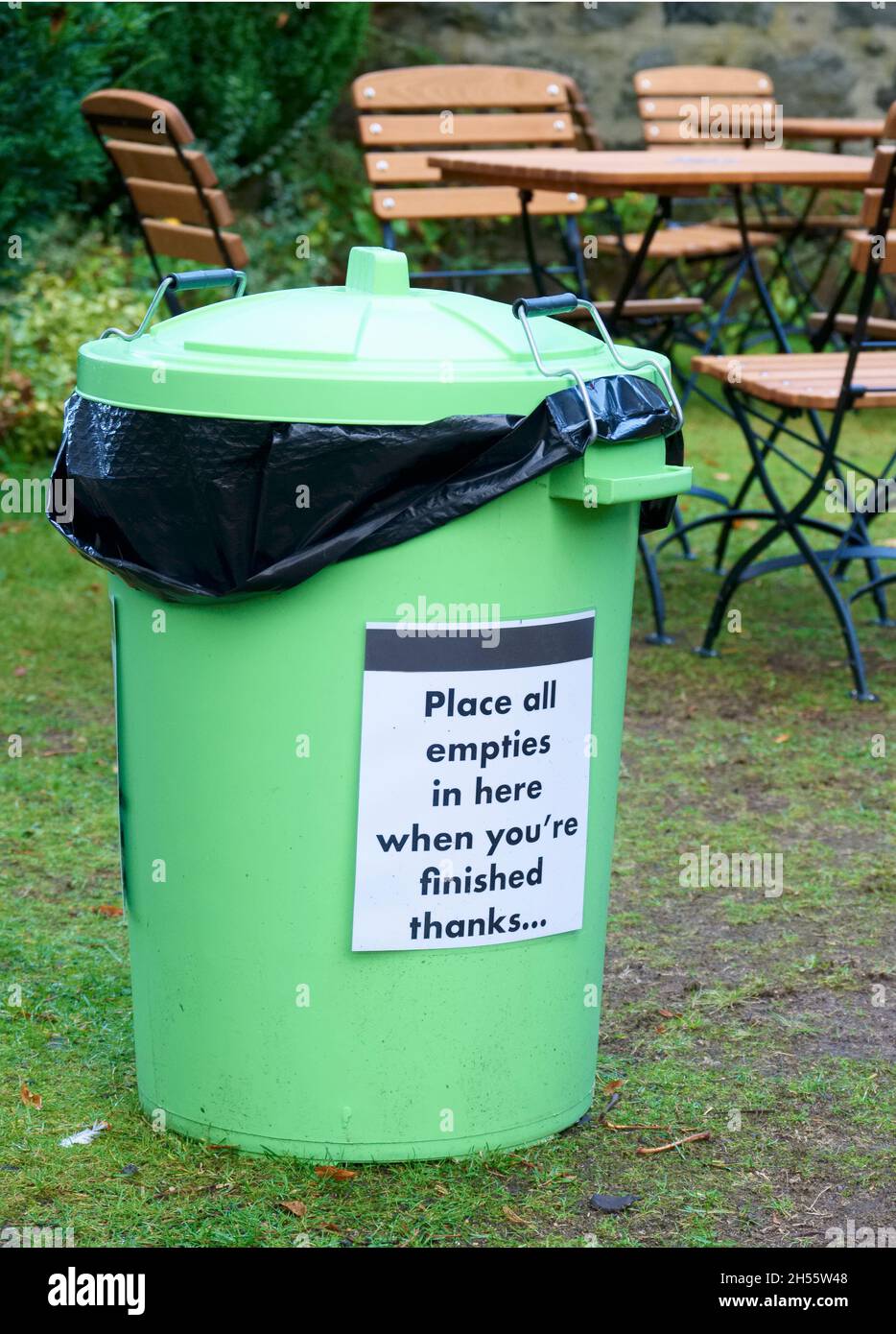 Green bin at outdoor cafe for garbage collection to keep area clean Stock Photo