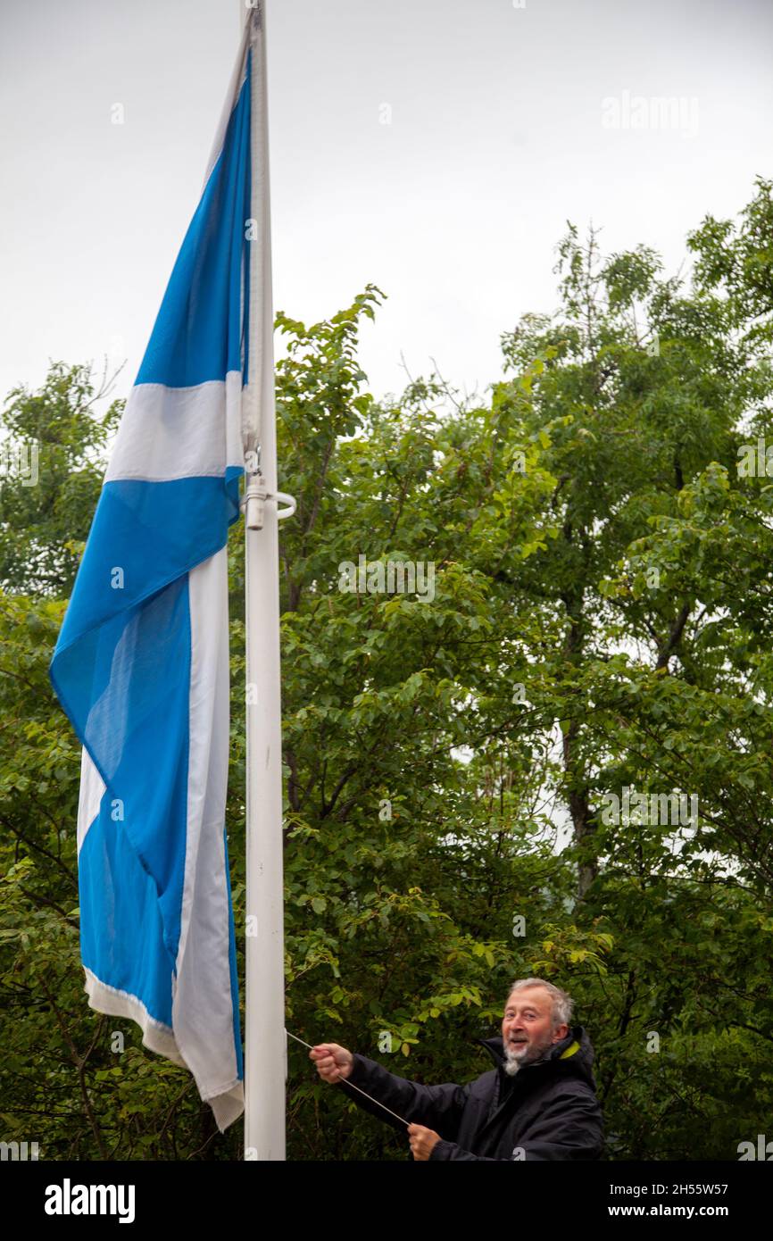 Local Man Hoisting Scottish Flag at National Wallace Monument, Scotland Stock Photo
