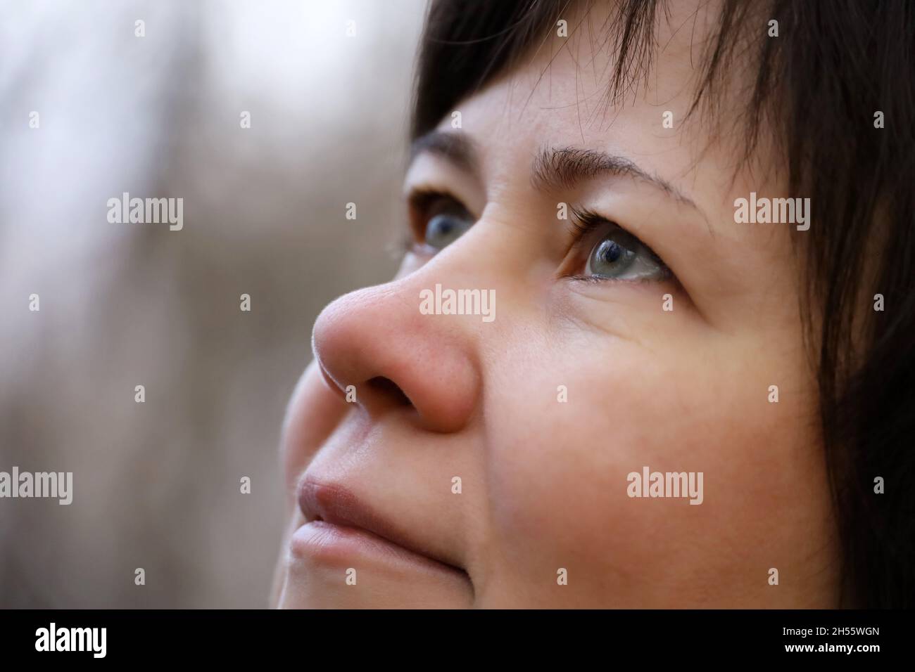 Portrait of woman looking up in autumn park. Concept of human vision, eye health Stock Photo
