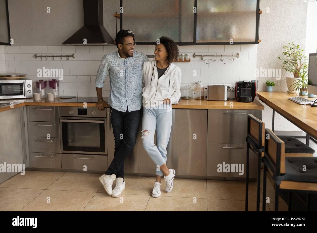 Young african american couple communicating in modern kitchen. Stock Photo
