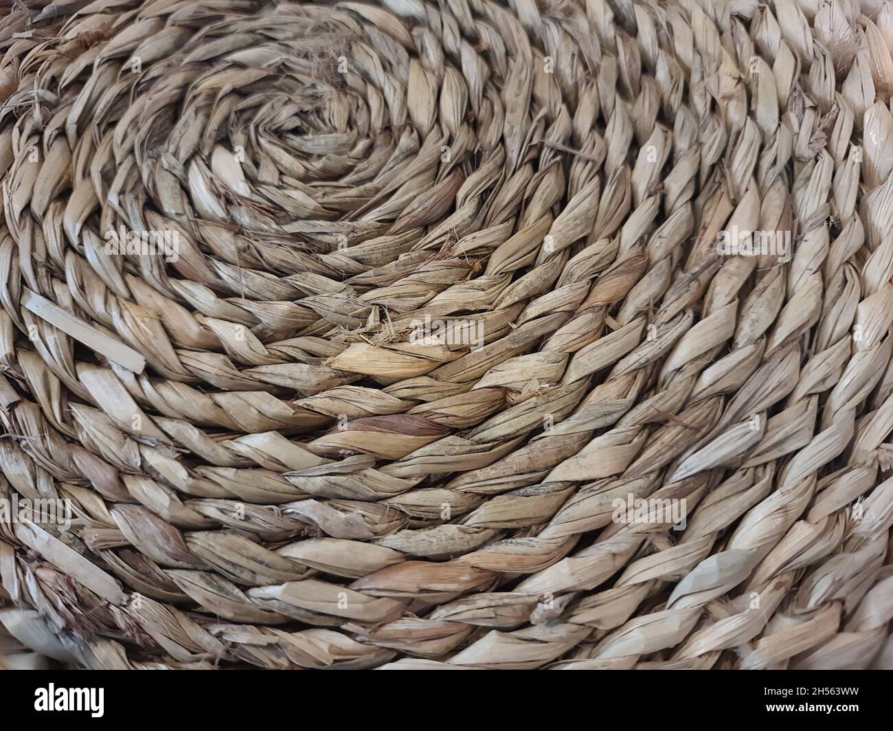 Natural fiber work, raw colored, in spiral shape, creative placemat, full screen, full screen. Stock Photo