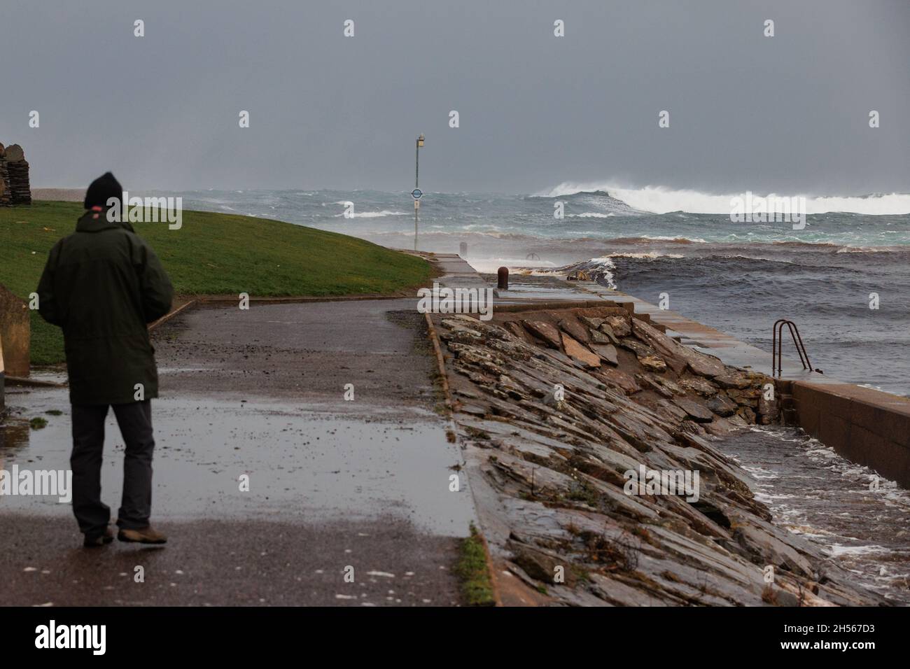 Thurso, Scotland. Nov. 7 2021. A man observes storm surf breaking at Thurso East. The waves were generated by gale force winds in the North Sea. Stock Photo