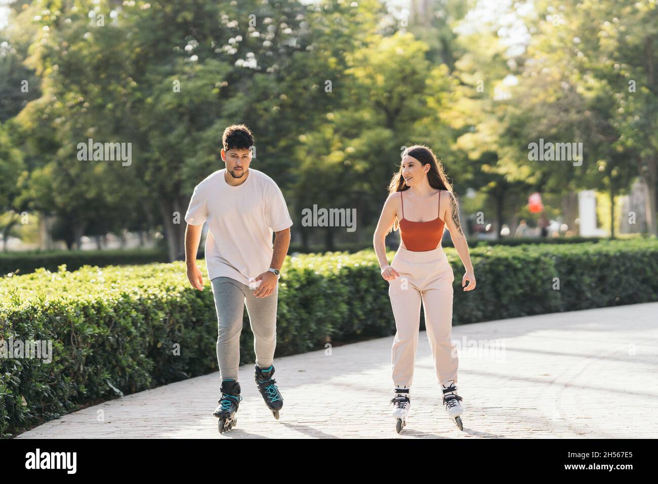 Young people skating relaxed using inline skates in a park Stock Photo