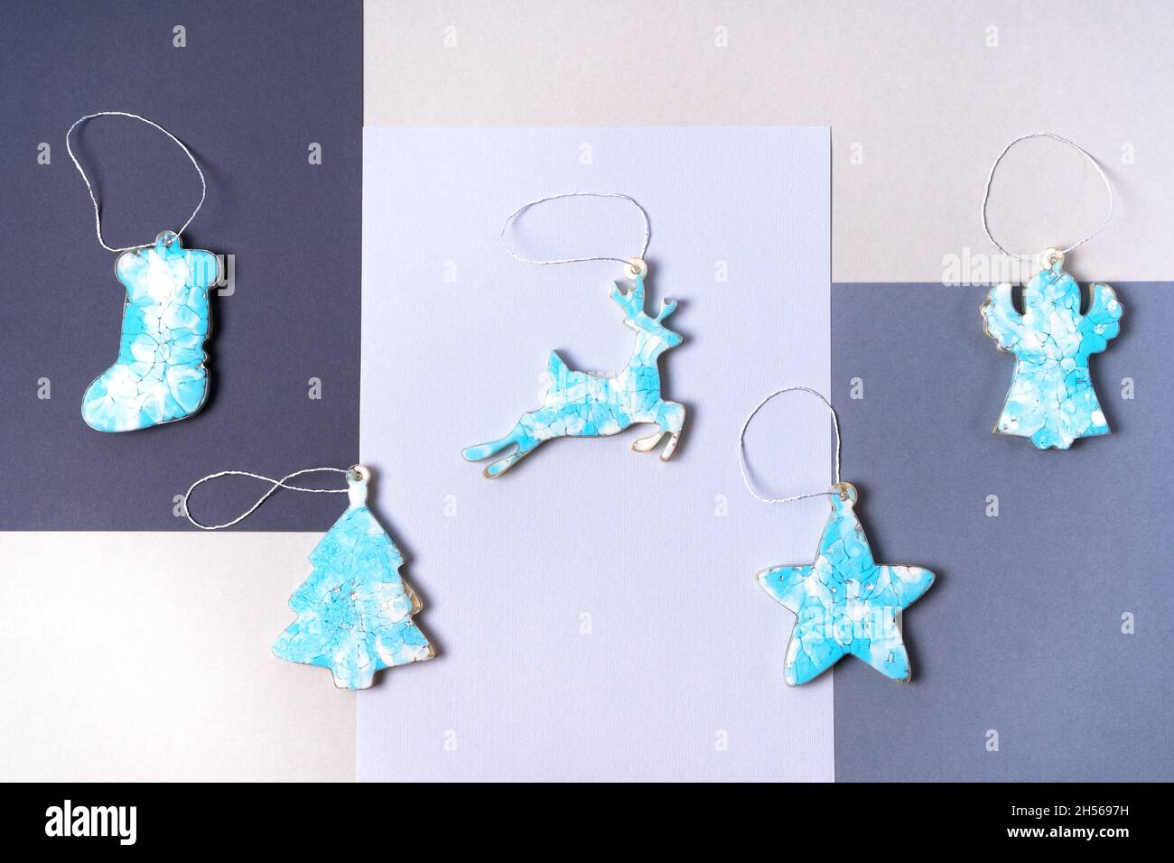 Blue Christmas decorations on a Christmas tree made of epoxy resin on a gray background. Christmas sock, star, deer, angel and tree. Top view Stock Photo
